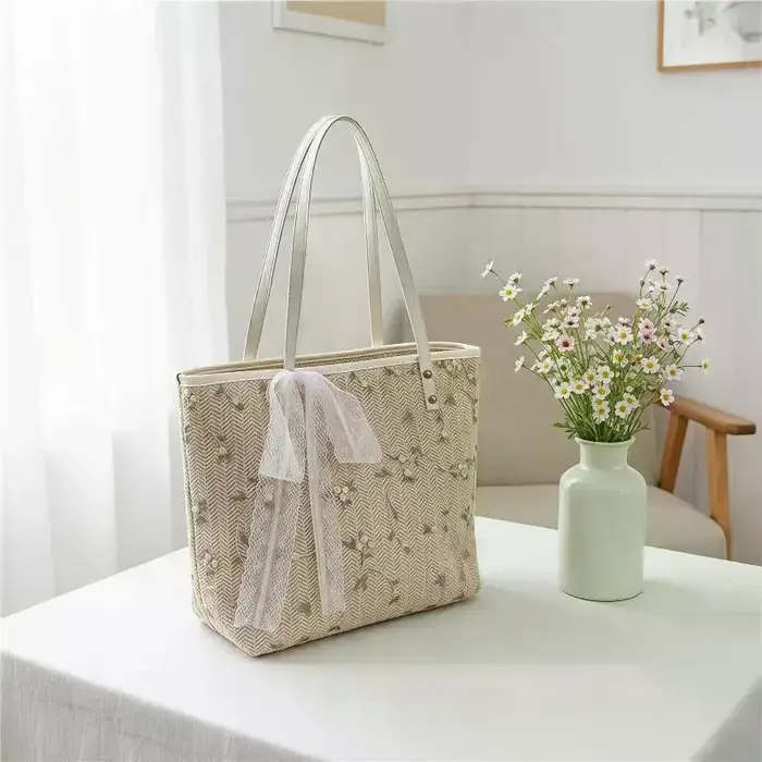 Sac fourre-tout en paille tressée avec broderie florale et détail nœud en dentelle